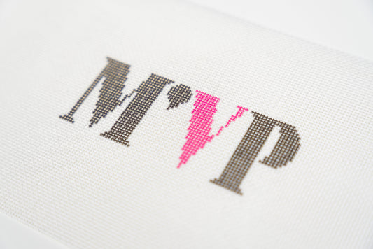 Close angled view of the charcoal M and P with the hot pink V on 13 mesh canvas