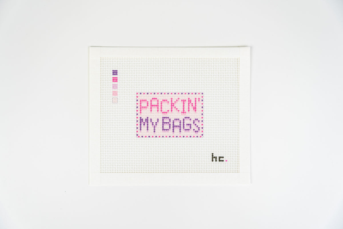 Printed needlepoint canvas reading packin my bags in hot pink and plum letters with a dotted plum border, Candy Pop colorway, on 13 mesh