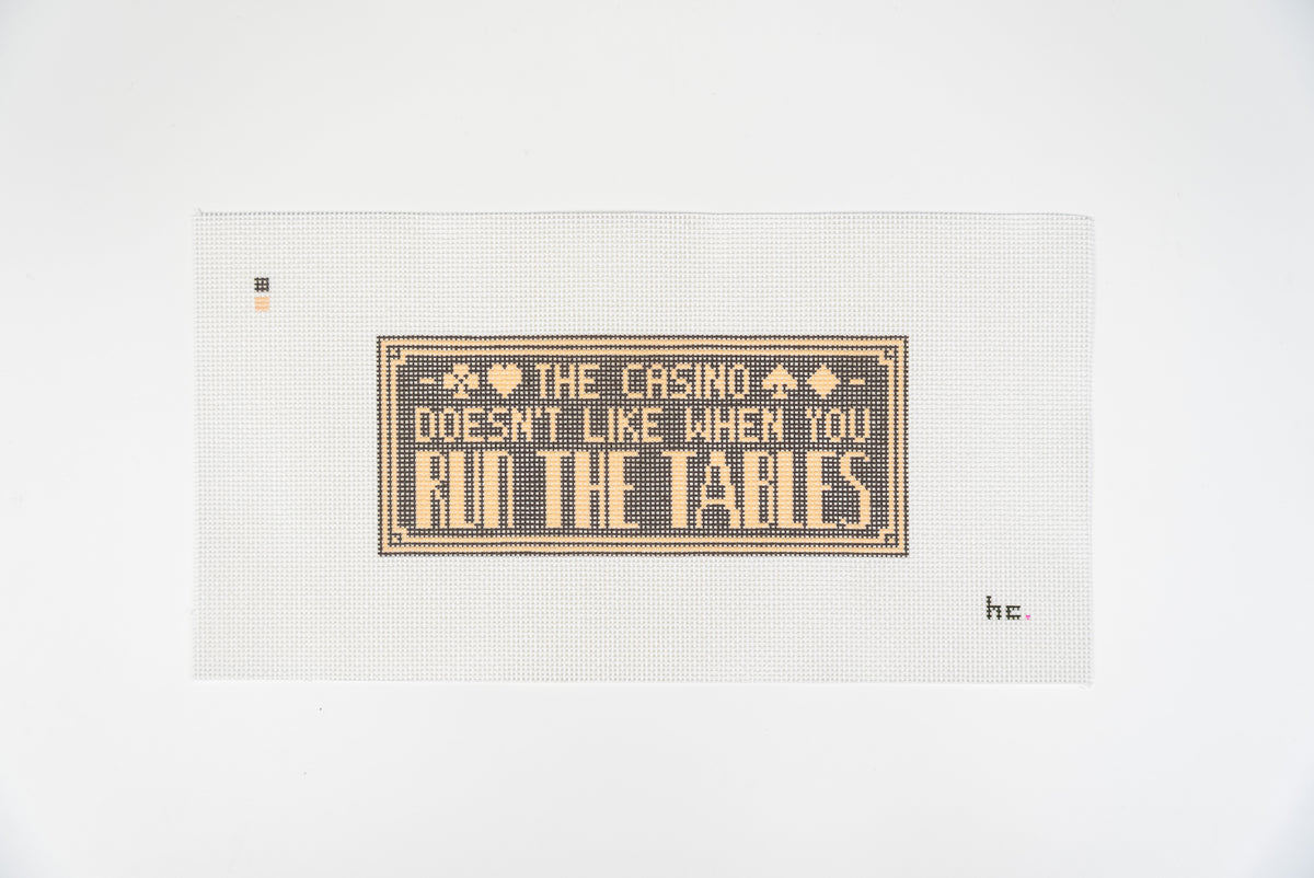 Run the Tables needlepoint canvas, soft gold lettering on a charcoal panel with a deco border and card suits, 13 mesh, full view