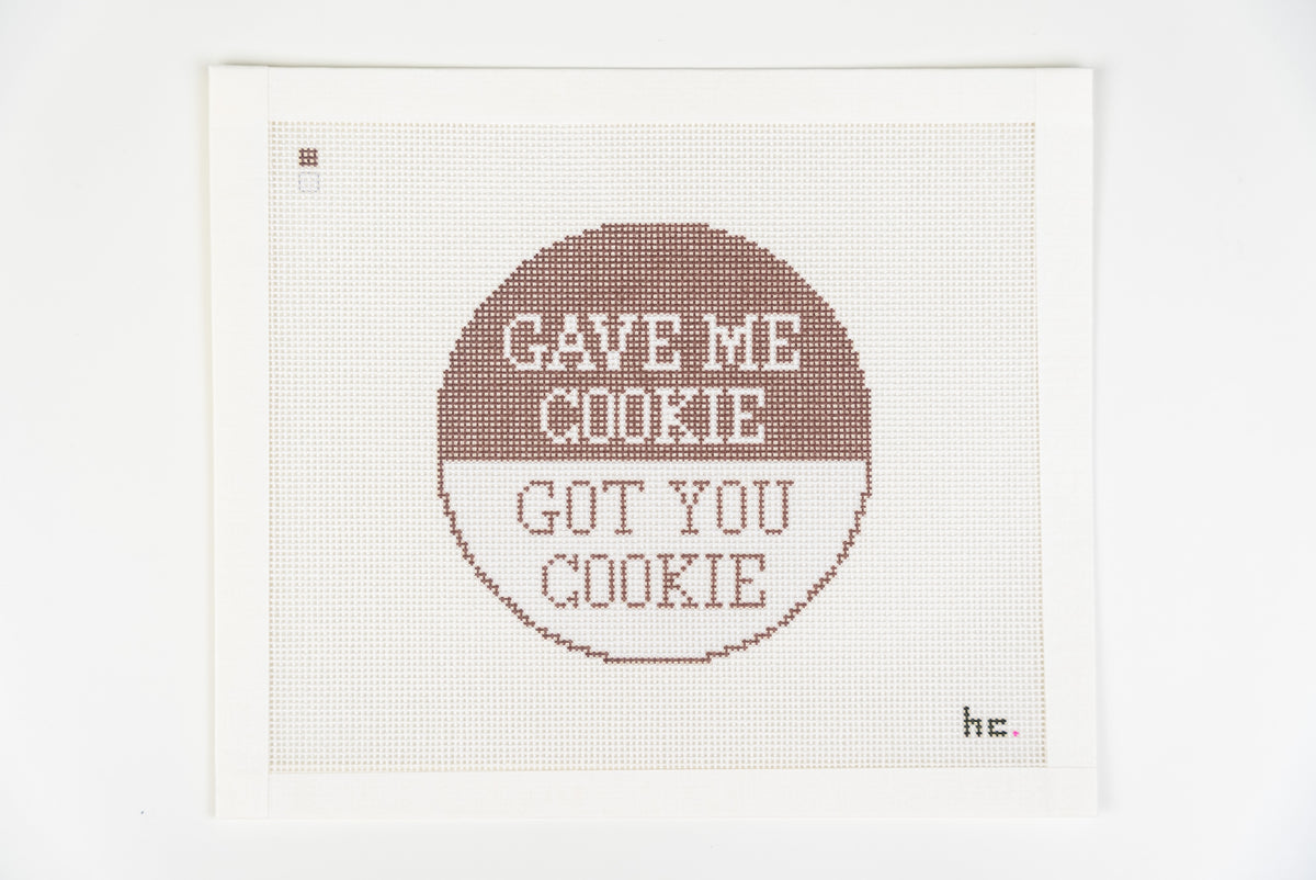 Printed needlepoint canvas with a round design, brown top half reading gave me cookie and white half reading got you cookie, 18 mesh, full view