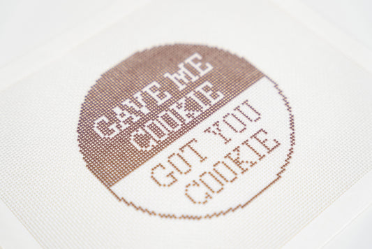 Printed needlepoint canvas, close angled view of the brown and white lettering on 18 mesh