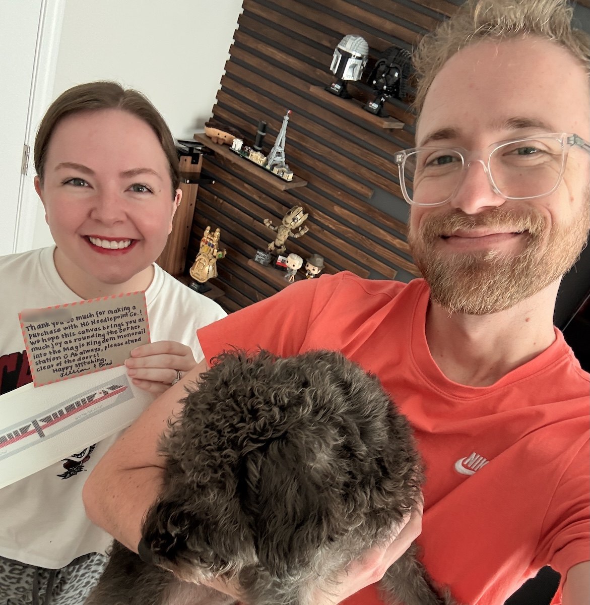 Jillian and Brad at home with Hammy, holding a handwritten thank-you note and a Monorail canvas